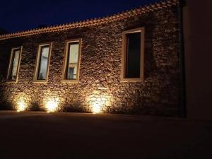 a building with lights on the side of it at night at Raízes Turismo Rural in Montes da Senhora