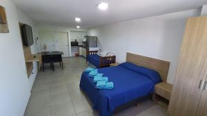 1 dormitorio con 1 cama azul y cocina en FARO PLAZA RIVADAVIA Alta Cordoba en Córdoba