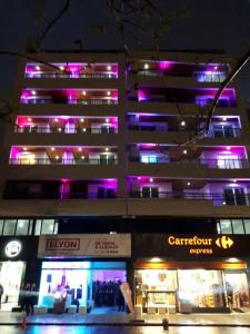 un edificio con luces púrpuras en el lateral. en FARO PLAZA RIVADAVIA Alta Cordoba en Córdoba