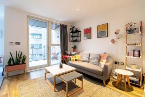 a living room with a couch and a table at Pass the Keys Cosy Studio flat with a Balcony in London