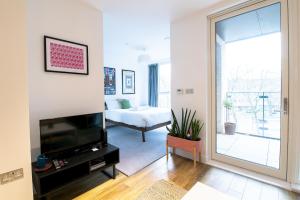 a living room with a television and a bedroom at Modern, Light-Filled Studio in Trendy North London in London