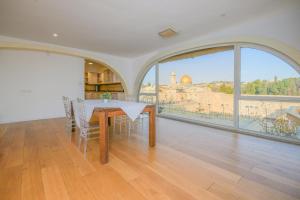 uma sala de jantar com mesa e vista para a cidade em Western Wall View Apartment em Jerusalém
