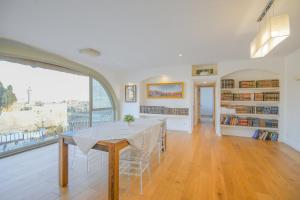 a dining room with a table and a large window at Western Wall View Apartment in Yerushalayim
