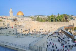 a crowd of people walking around the western wall at Western Wall View Apartment in Yerushalayim