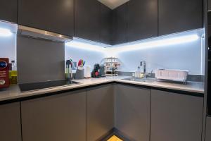 a kitchen with white cabinets and a sink at Modern, Light-Filled Studio in Trendy North London in London