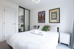 a white bedroom with a large white bed at Modern, Light-Filled Studio in Trendy North London in London