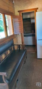 a kitchen with a bench in a room with a refrigerator at Drulenu sodyba 