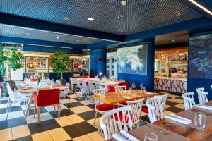une salle à manger avec des tables et des chaises dans un restaurant dans l'établissement Best Western Plus Hôtel Le Rhénan & Restaurant Chez Claude, à Dorlisheim