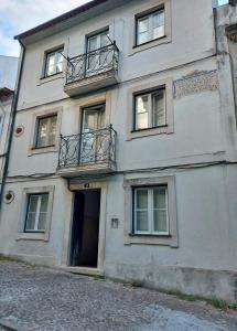 a white building with a door and a balcony at Casa da Universidade in Coimbra
