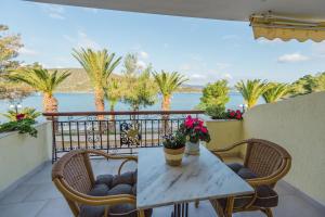 a table and chairs on a balcony with a view of the water at Philoxenia Ganossis in Ermioni
