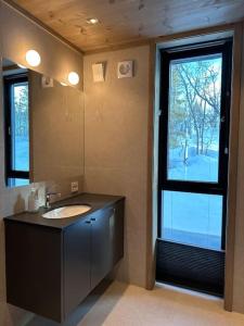 a bathroom with a sink and a mirror and a window at Tiltalende hytte med fin utsikt in Beitostøl