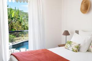 a bedroom with a bed and a view of a pool at ESCAPADE BELLEPIERRE (L') in Saint-Denis
