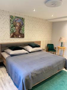 Komfort Zone في فولفسبورغ: غرفة نوم بسرير كبير عليها لوحة على الحائط