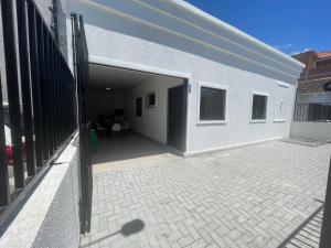 - un bâtiment avec une porte ouverte et une terrasse dans l'établissement Casa a 40 metros da praia, rua tranquila, à Penha