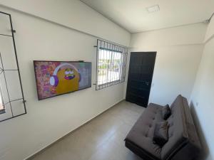 uma sala de estar com um sofá e uma janela em Casa a 40 metros da praia, rua tranquila em Penha