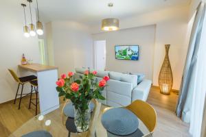 a living room with a couch and a table with roses at Philoxenia Ganossis in Ermioni