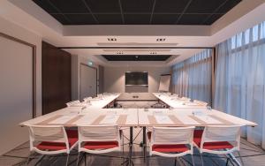 une salle de conférence avec une grande table et des chaises dans l'établissement Best Western Plus Hôtel Le Rhénan & Restaurant Chez Claude, à Dorlisheim