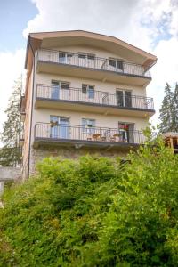 新瓦羅許的住宿－Apartmani Rvović，公寓大楼设有阳台和树木