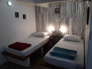 two beds in a small room with two at Hospedagem Casa de Pedro in Santos