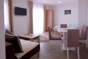 ein Wohnzimmer mit einem Sofa und einem Tisch in der Unterkunft Apartmani Rvović in Nova Varoš