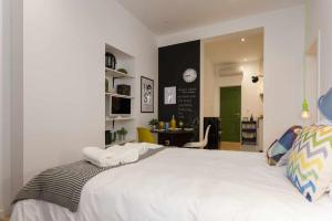um quarto com uma grande cama branca num quarto em Green Centro da Cidade Ar Condicionado em Lisboa