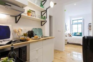 a kitchen with a counter top and a room with a bed at Green Centro da Cidade Ar Condicionado in Lisbon
