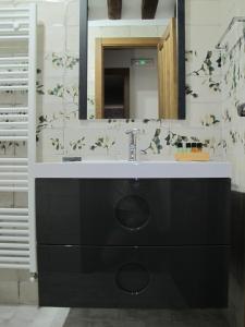 uma casa de banho com um lavatório e um espelho em Apartamentos Turísticos La Casa Grande em Arévalo