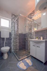 新瓦羅許的住宿－Apartmani Rvović，带淋浴、卫生间和盥洗盆的浴室
