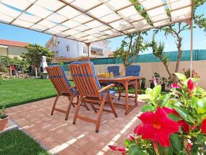 un patio con tavolo e sedie sotto un pergolato di Apartments Zadro a Tribunj (Trebocconi)