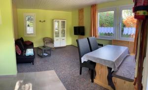 ein Wohnzimmer mit einem Tisch und einem Sofa in der Unterkunft Feriendorf Boeker Mühle in Boek