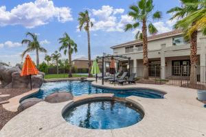 una piscina con palmeras y una casa en Leland Luxury, en Mesa
