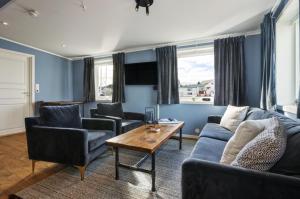 a living room with a couch and chairs and a table at Tobiasbrygga in Henningsvær