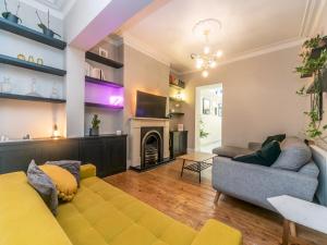 a living room with a yellow couch and a fireplace at Pass the Keys Beautiful Spacious Home in London