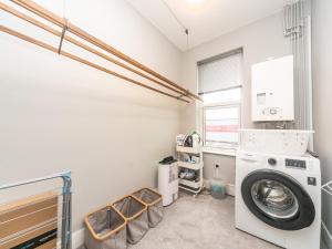 a laundry room with a washer and dryer at Pass the Keys Beautiful Spacious Home in London