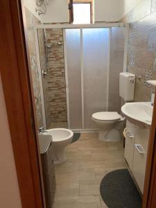 a bathroom with two toilets and a shower and a sink at Villa Dei Pini in San Pietro in Bevagna