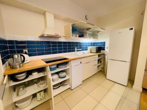cocina con electrodomésticos blancos y azulejos azules en Golden Dune 100m od plaży, en Międzyzdroje