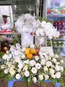 une exposition de fleurs et de fruits blancs sur une table dans l'établissement Hotel Hương Đào, à Côn Son