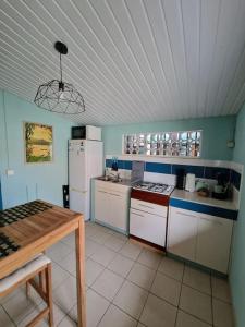 a kitchen with white appliances and a table in it at Logement privatif avec piscine & barbecue partagés in Kourou