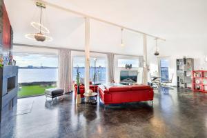 - un salon avec un canapé rouge et une grande fenêtre dans l'établissement Panoramalodge Rügen, à Altefähr