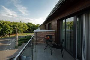 einen Balkon mit einem Tisch und einem Stuhl darauf in der Unterkunft Almásy Apartmanház Gyula in Gyula