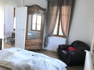 1 dormitorio con cama, silla y espejo en Il était une fois, en Saint-Yrieix-la-Perche
