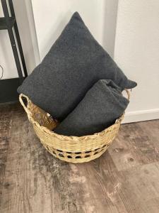 a black pillow sitting in a basket on the floor at Historischer Ohlerich Speicher Hafen Wismar Ap.18 in Wismar