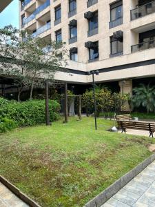 a park with a bench in front of a building at Flat maravilhoso em frente aeroporto de Congonhas Nobile in São Paulo