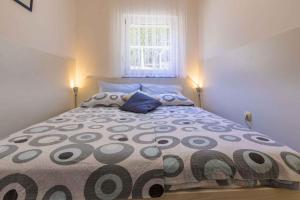 1 dormitorio con 1 cama grande con 2 almohadas y ventana en One-Bedroom Apartment in Crikvenica XVI, en Dramalj