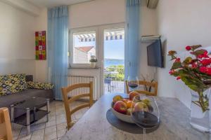 a living room with a table with a bowl of fruit at One-Bedroom Apartment in Crikvenica XVI in Dramalj