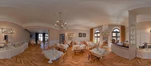 a dining room with tables and chairs and a chandelier at Willa Pod Aniołem in Inowrocław
