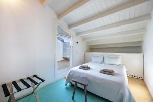 1 dormitorio con cama blanca y ventana en Olinda House, en Odeceixe