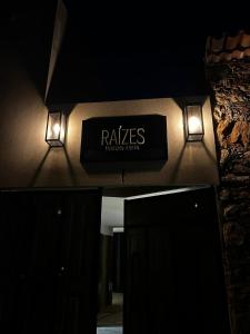 a sign on the wall of a building with lights at Raízes Turismo Rural in Castelo Branco