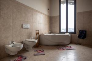 a bathroom with a tub and a toilet and a sink at Villa Cavalieri in Vedriano in Roncovetro +15 photos