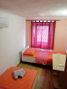a bedroom with two beds and a pink window at Hostel Martin in Koper